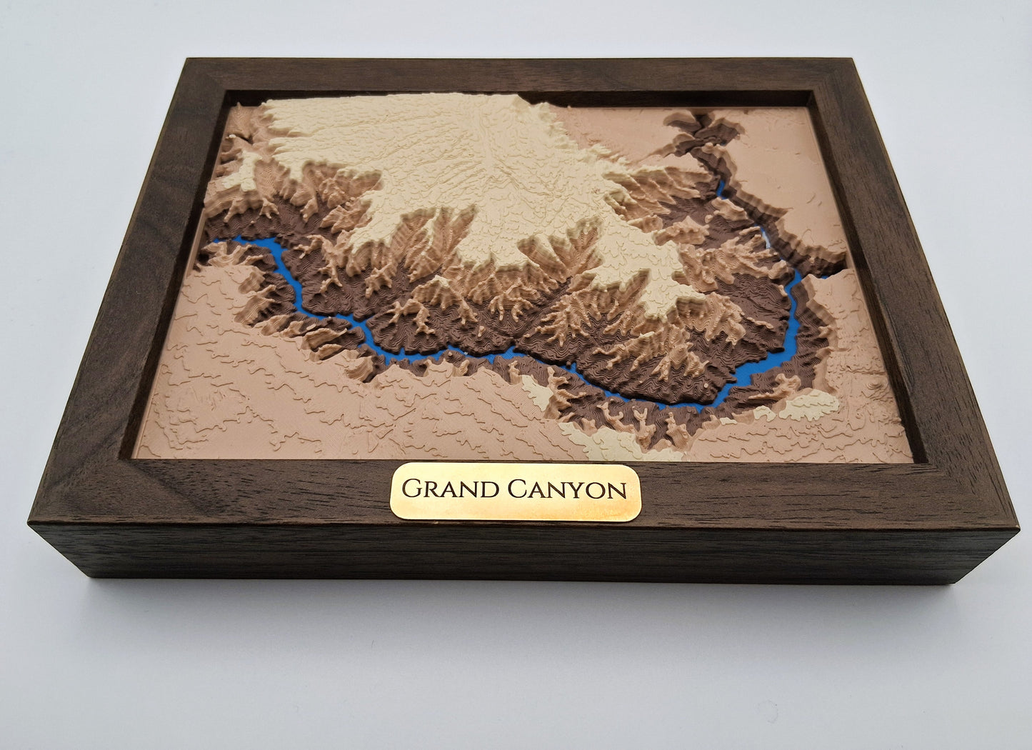 Wooden model of the Grand Canyon with a brown frame and gold 'Grand Canyon' label on a light gray background.