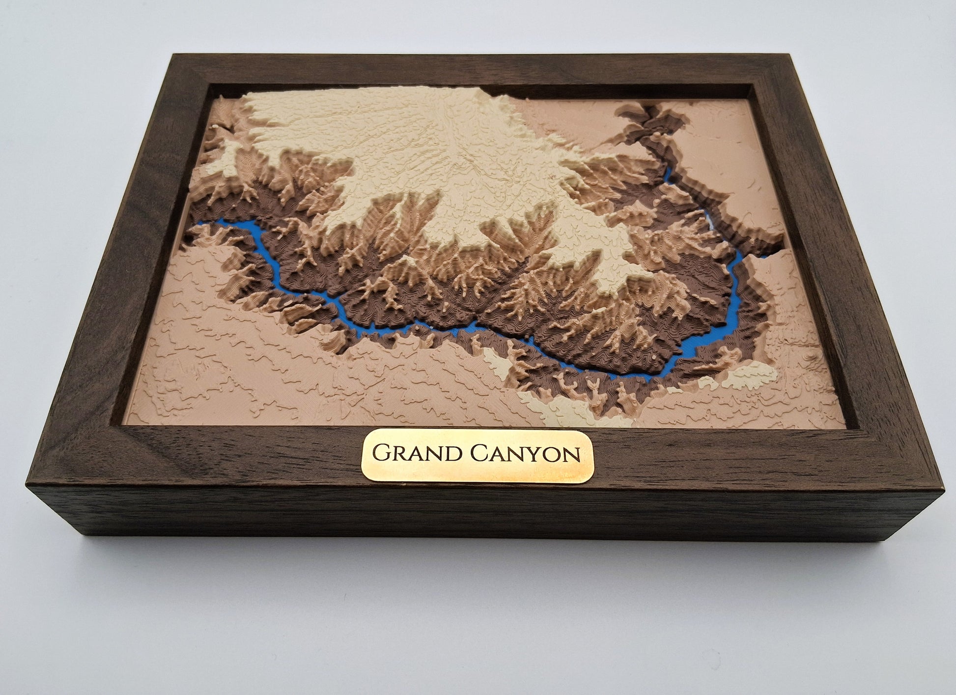 Wooden model of the Grand Canyon with a brown frame and gold 'Grand Canyon' label on a light gray background.