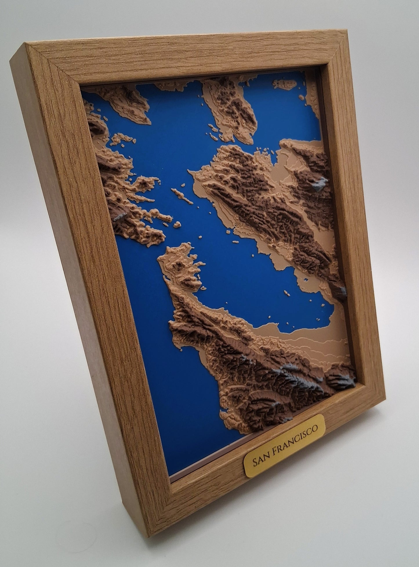 Wooden framed topographic map of San Francisco with a blue background