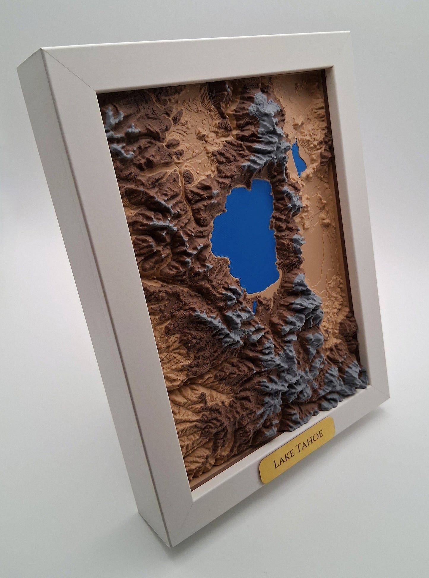 Topographic map of Lake Tahoe in a white frame on a light gray background