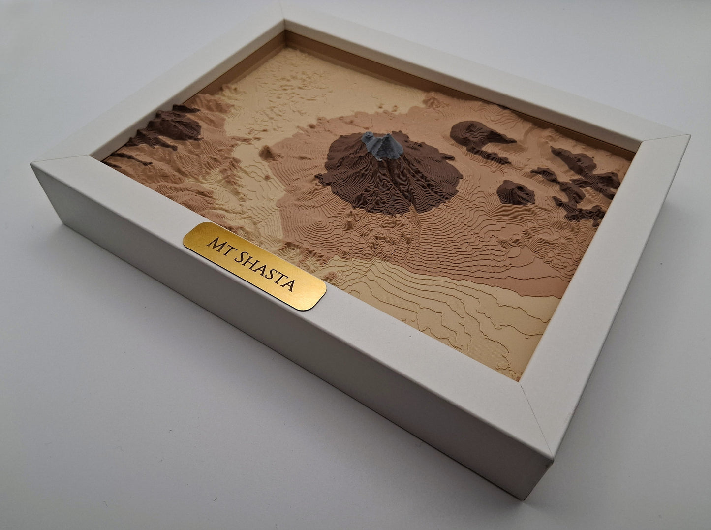 Model of Mount Shasta in a box on a white background