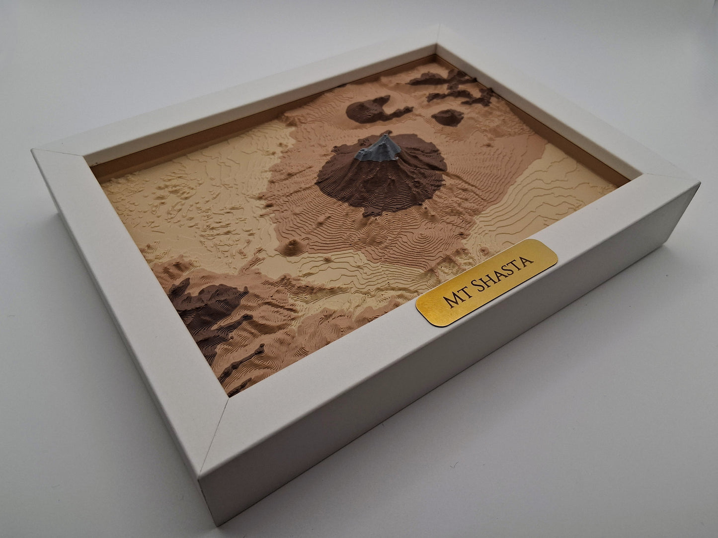 Model of Mount Shasta in a box on a white background
