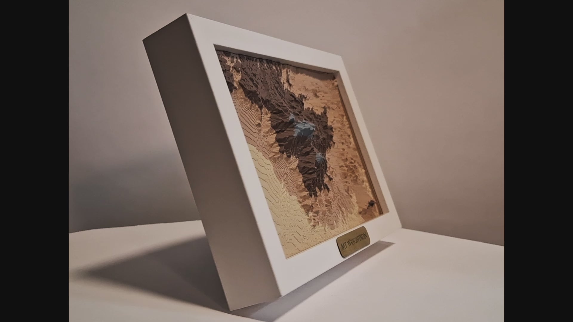 Video of a 3d topographic print of mount wrightson and madera canyon in a white frame slowly spinning.