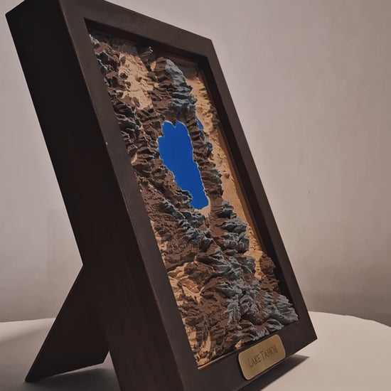 Topographic model of Lake Tahoe in a walnut frame on a light gray background